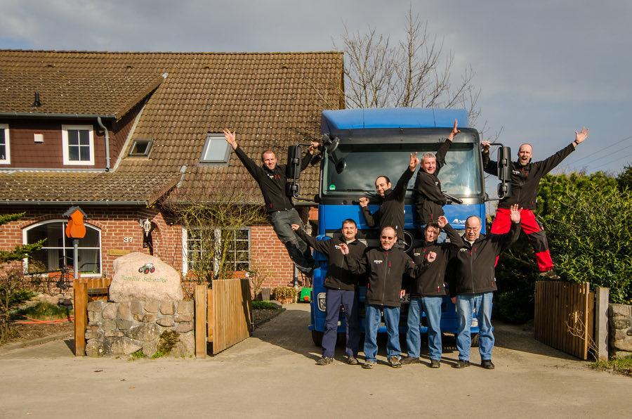 Lkw-Fahrer-Team von Bauer Schwutke vor einem Lastwagen